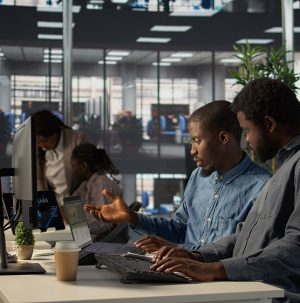Black corporate team collaborate on global investment strategy Black corporate team collaborate on global investment strategy, employing their extensive business expertise to work on data driven decisions. Solving administrative tasks for efficiency. Camera B.